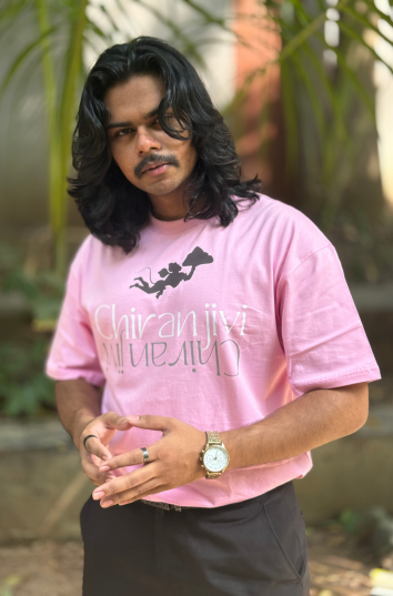 man wearing parambhakt chiranjeevi oversized t-shirt in pink color with nature background