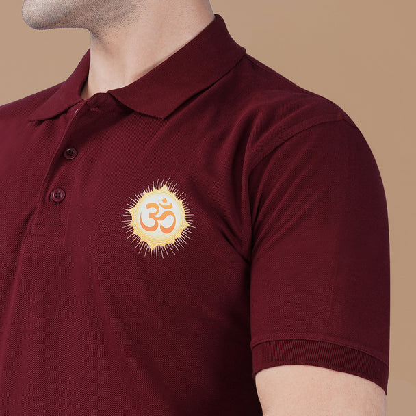 Close-up of the Om symbol artwork printed on the maroon Parambhakt polo T-shirt representing spiritual energy and devotion.