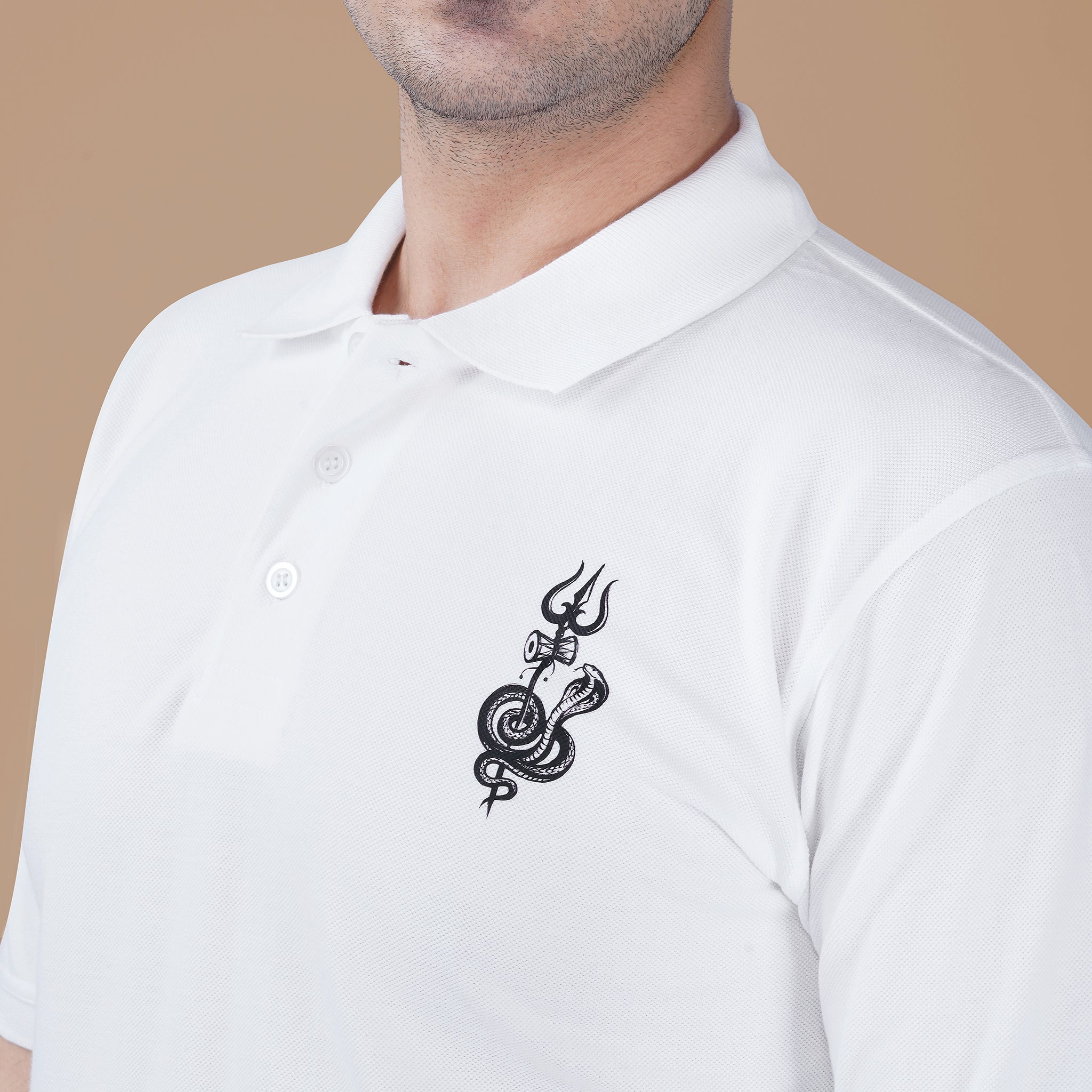Close-up of the Shivji Trishul inspired artwork on the white Parambhakt polo shirt highlighting the spiritual design detail.